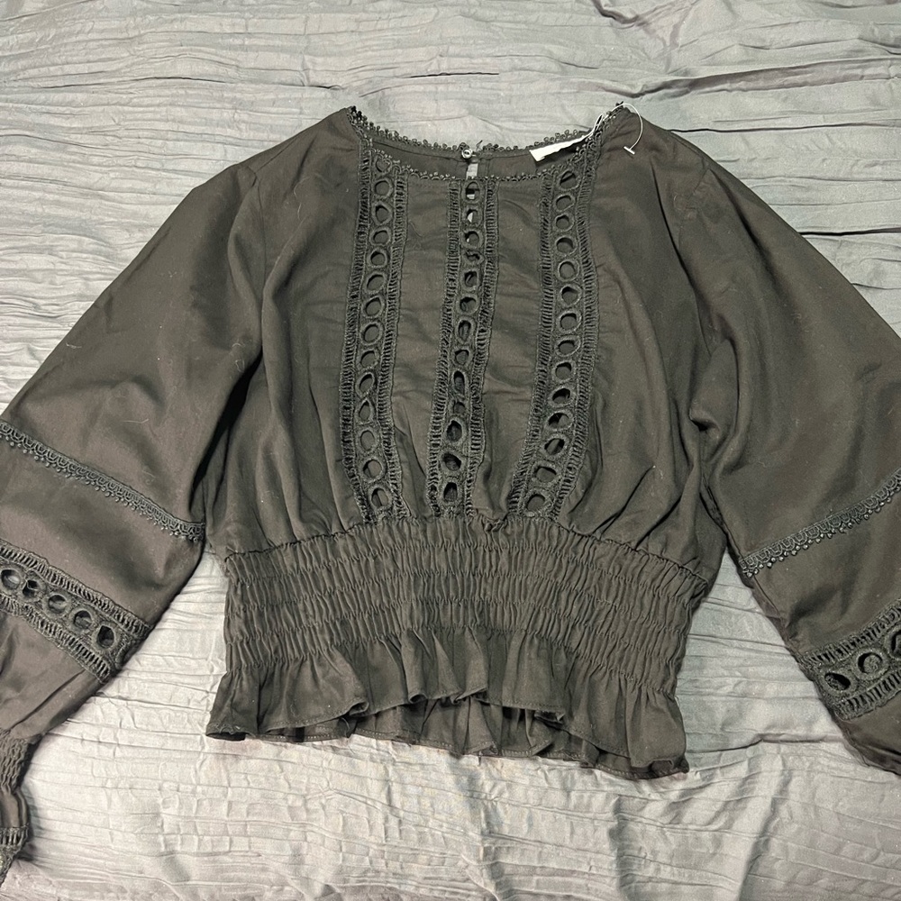 Cropped black top.  Size small. Revealing holes through front.